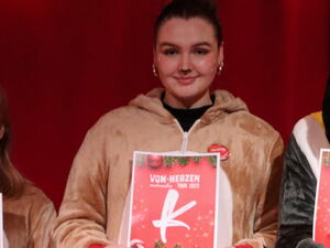 8 Personen. Viele im Rentier-Kostüm, einer als Pinguin verkleidet. Sie halten roter Schilder mit Buchstaben hoch die das Wort DANKE! bilden.