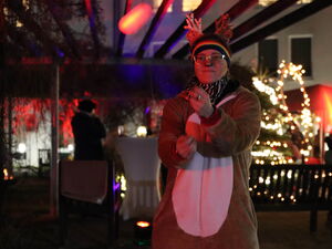 Frau mit Brille im Rentier-Kostüm, dahinter Lichterketten.