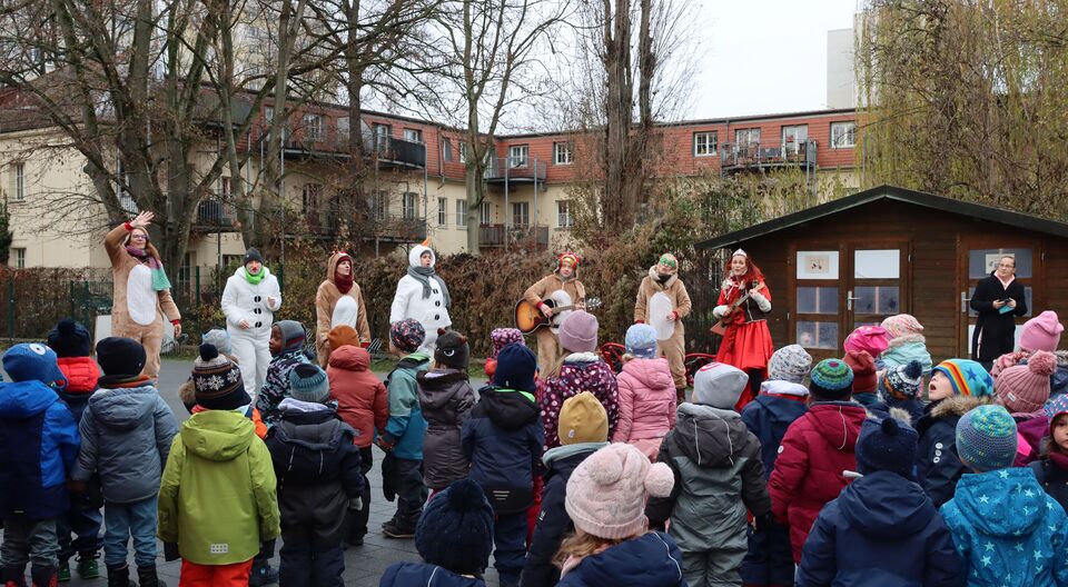Staunende Kinder zwischen singenden Rentieren