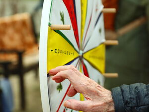 Eine Hand dreht am Glücksrad.